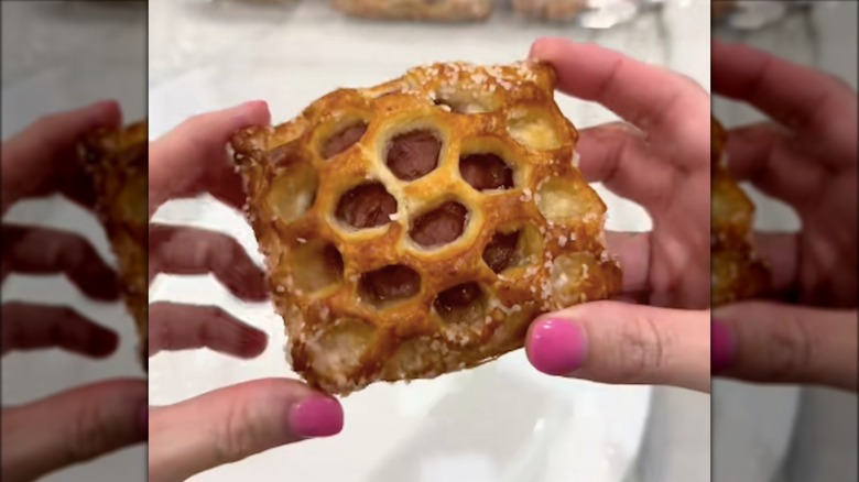 Hands with pink nails holding Costco's Strawberry Rhubarb Pastry