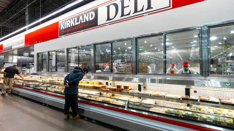 Shopper looking at prepared meals at Costco's deli section.