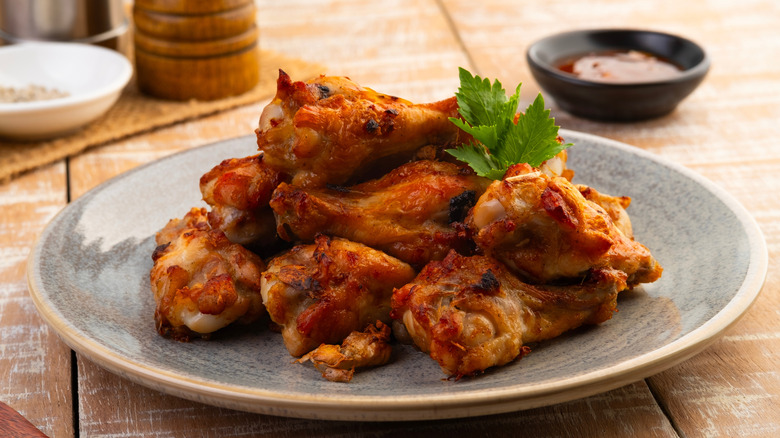 chicken wings piled on gray plate with garnish