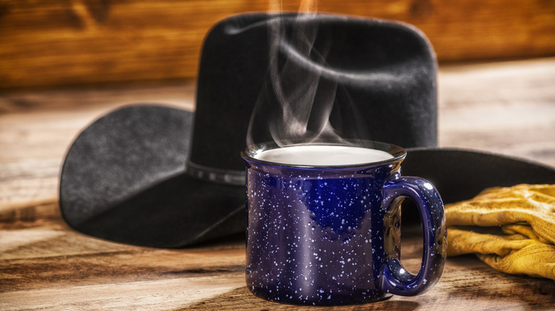 Steaming mug with black cowboy hat