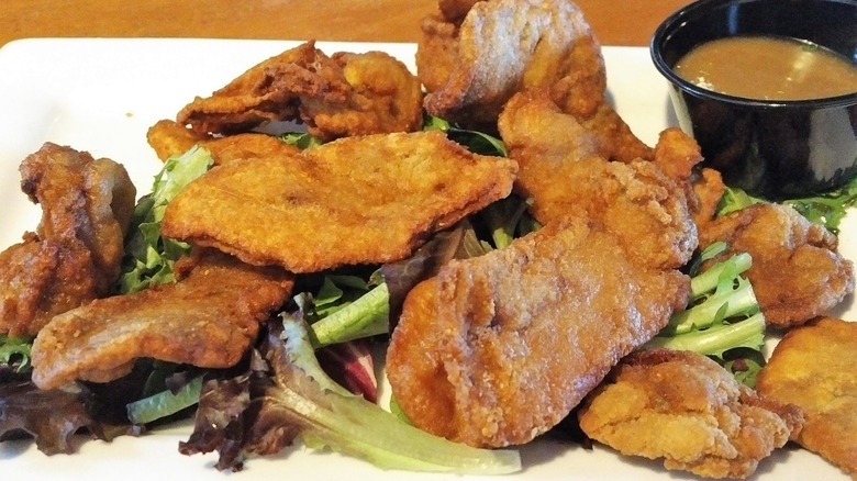 Plate of fried Rocky Mountain Oysters with greens and dipping sauce