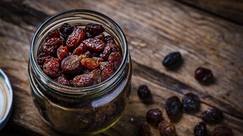 Raisins in a glass jar on a wooden table