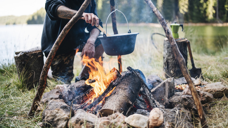 Stew cooking in a pot, hanging over a campfire.