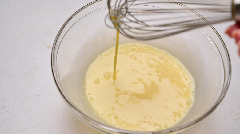 egg running smoothly off of a whisk into a bowl