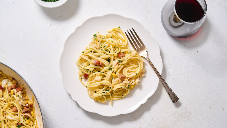 carbonara pasta with crab and sausage on plate
