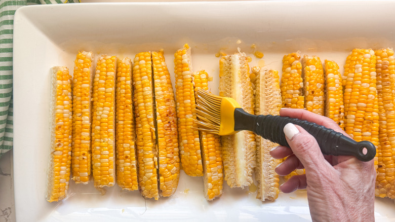 hand brushing ribs with oil