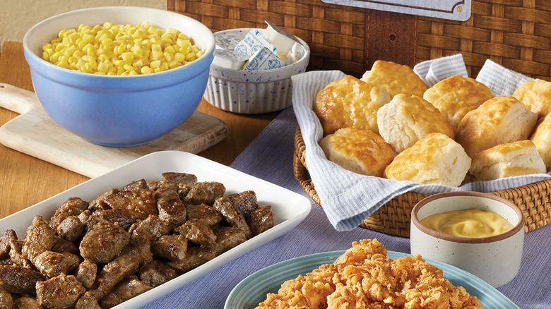 Food from Cracker Barrel like a bowl of corn, a ramekin of butter, biscuits in a basket and more.