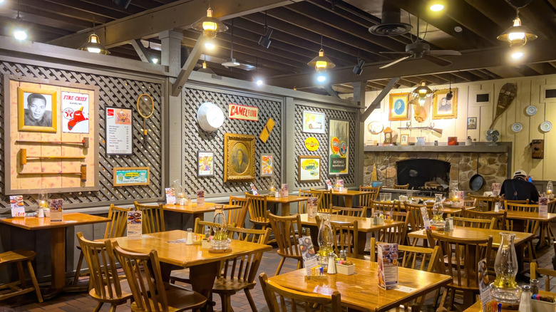 The interior of a Cracker Barrel restaurant with a lone diner facing the wall