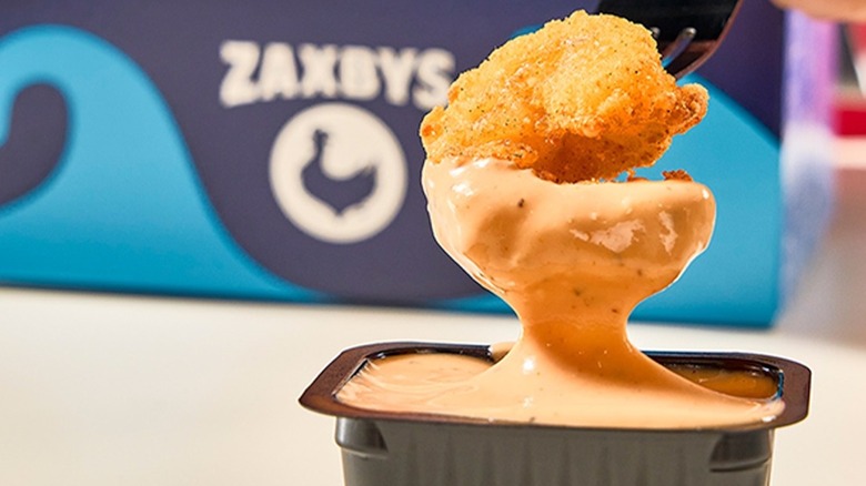 customer dipping nugget into Zaxby's Zax sauce