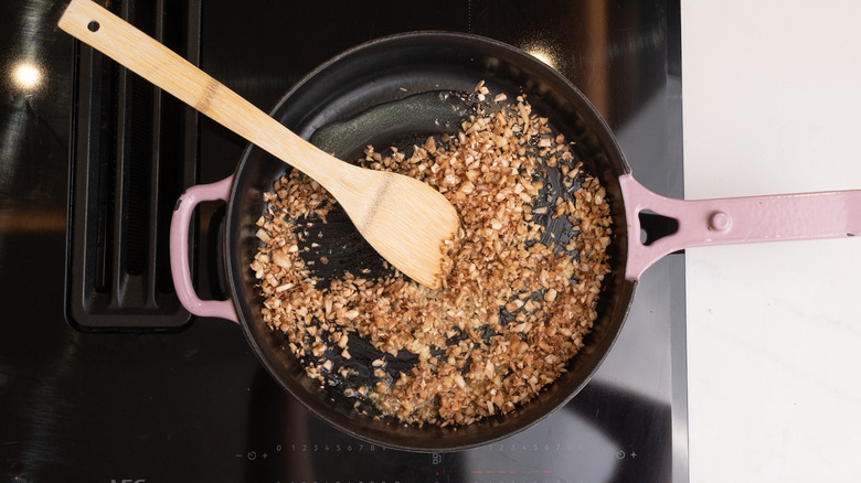 finely chopped mushroom stems cooking in pan