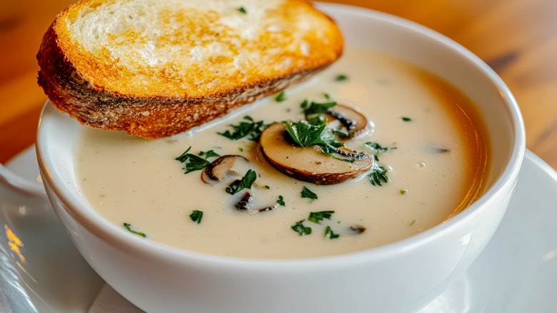 mushroom soup with a slice of baguette