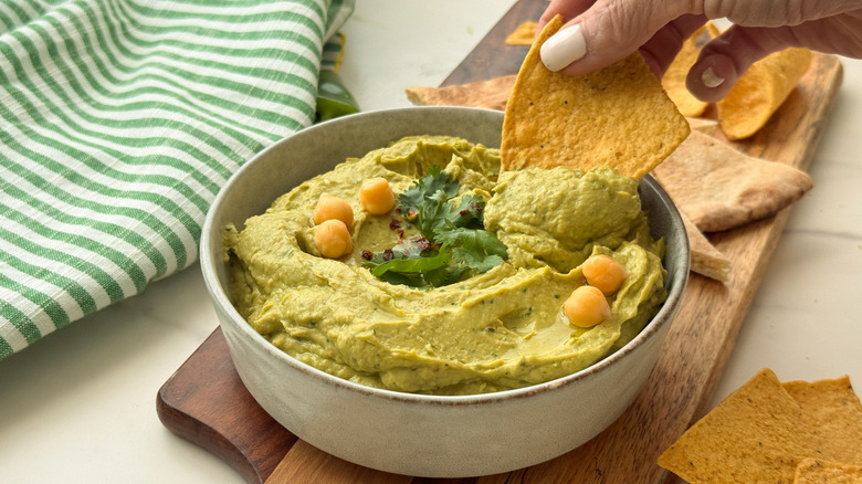 hand dipping in hummus
