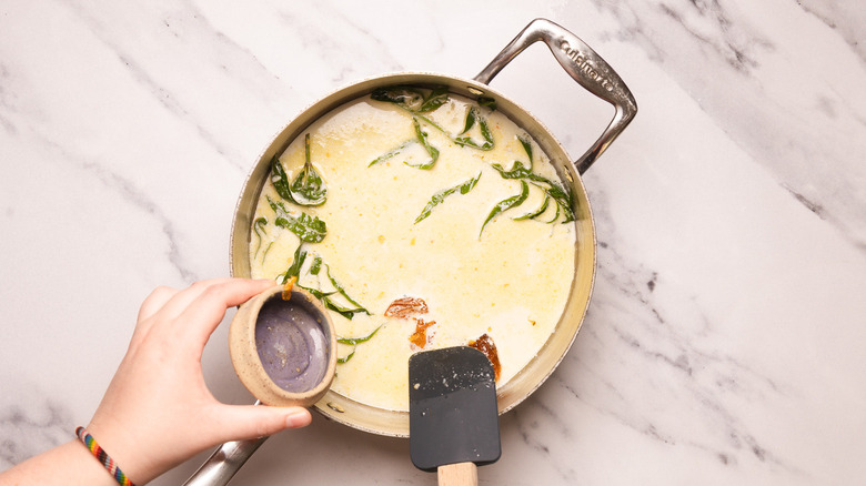 Adding marmalade to creamy sauce.