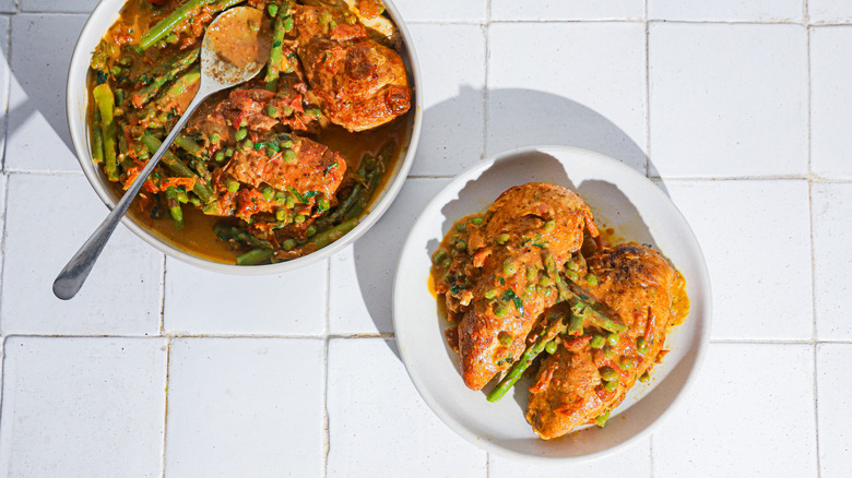 chicken breasts with tomato sauce, peas, and asparagus on plare