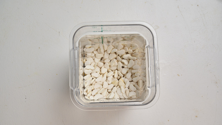 Beans covered with water in a container