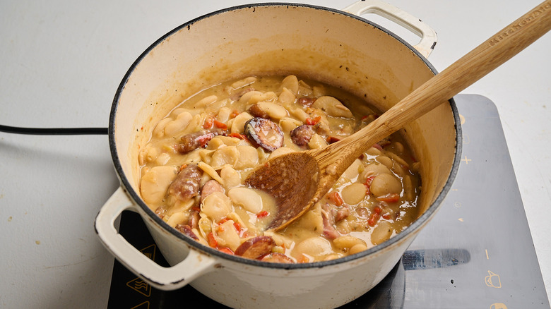 pot of cooked beans with a wooden spoon