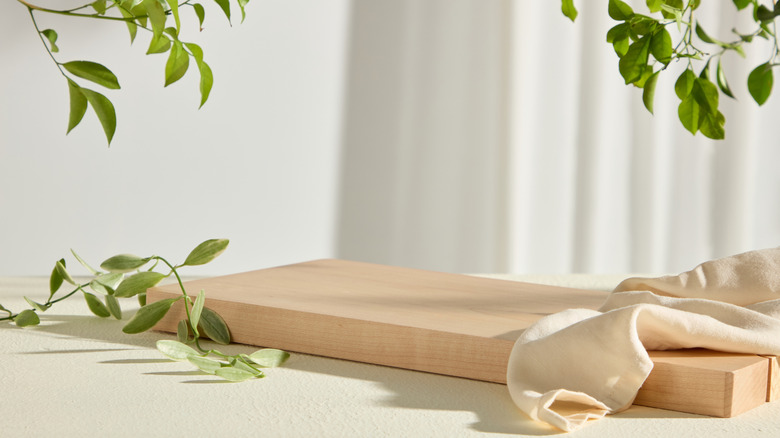 Wooden tray on counter with napkin, plants