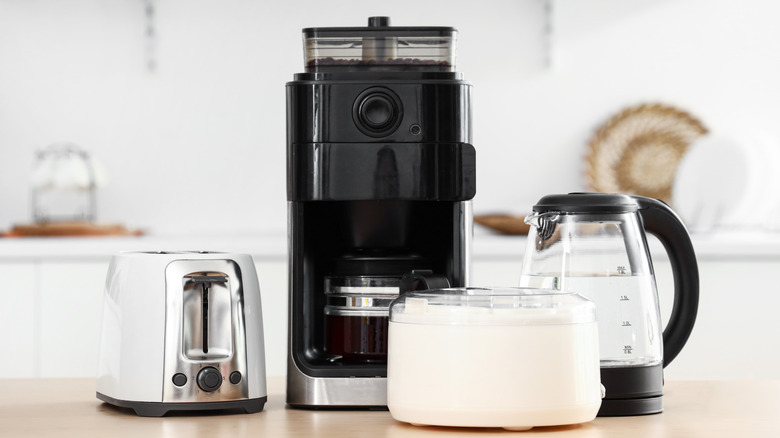 Wooden table with a set of modern kitchen appliances