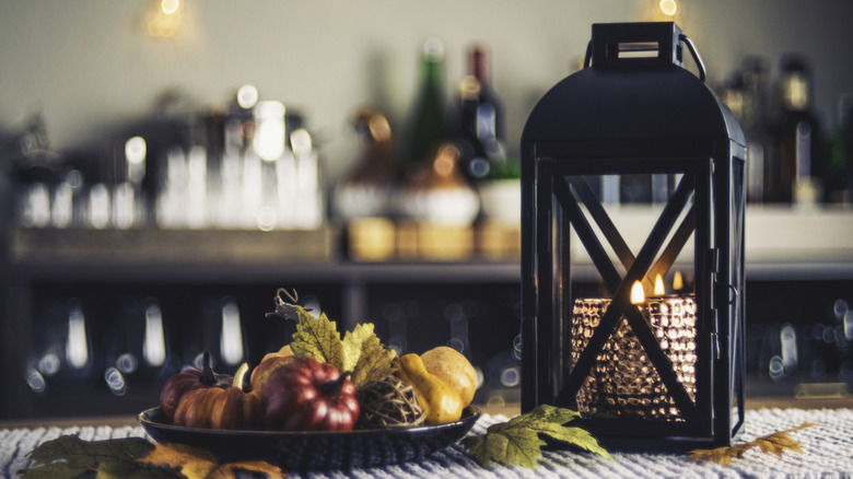 Table set with candle and lantern centerpiece and fall decor