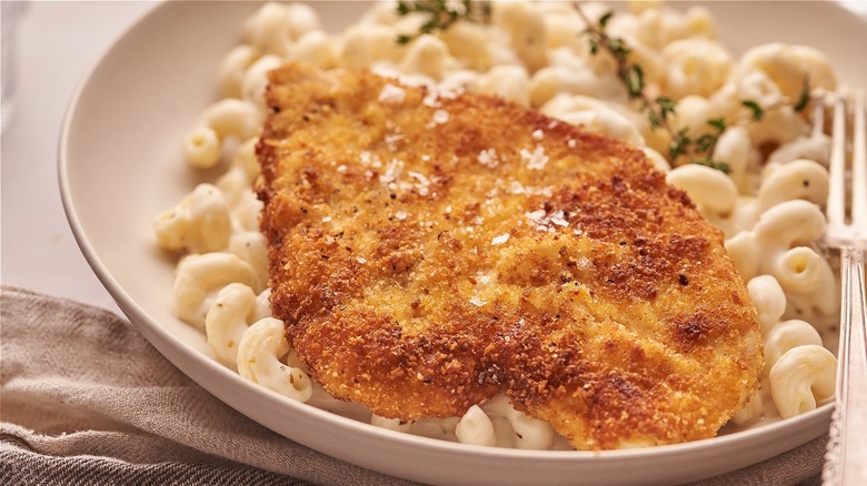chicken cutlet on a plate of pasta