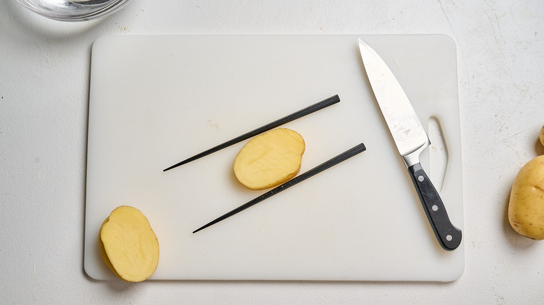 slicing potato diagonally across