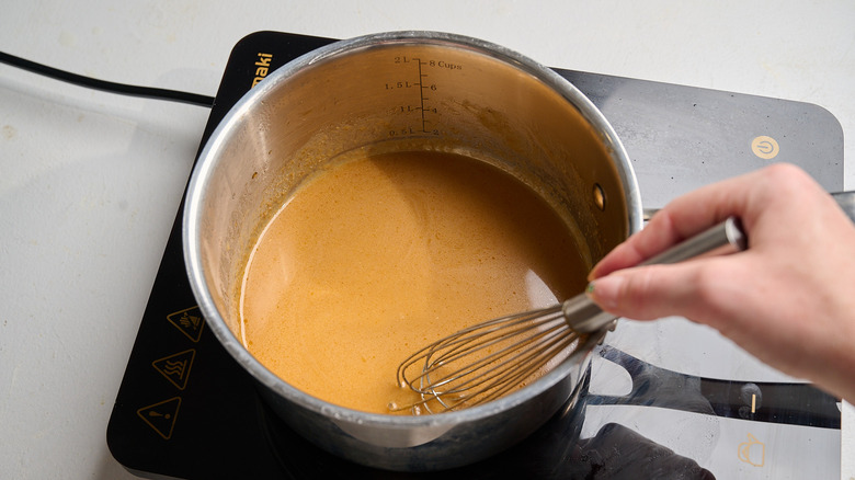 stirring thinned sauce in saucepan