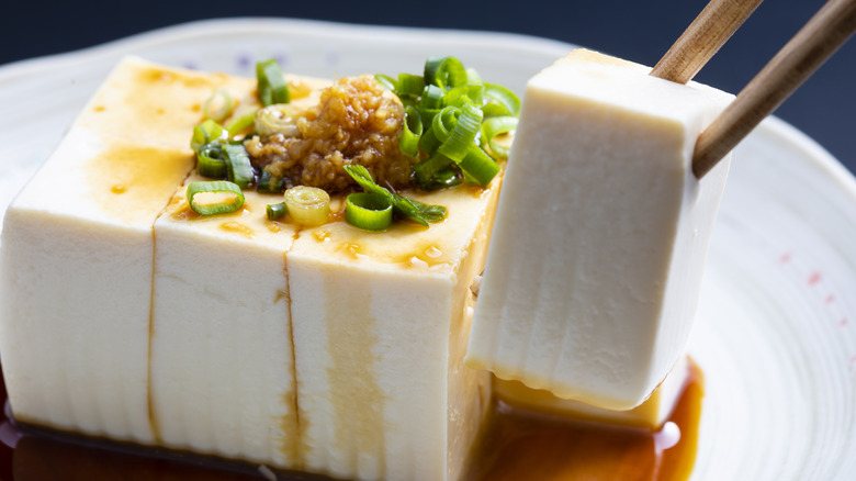 Tofu with ginger soy sauce on a white plate