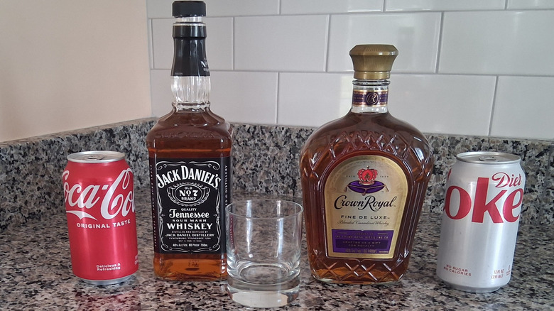 bottles of Crown Royal and Jack Daniel's with regular and Diet Coke cans