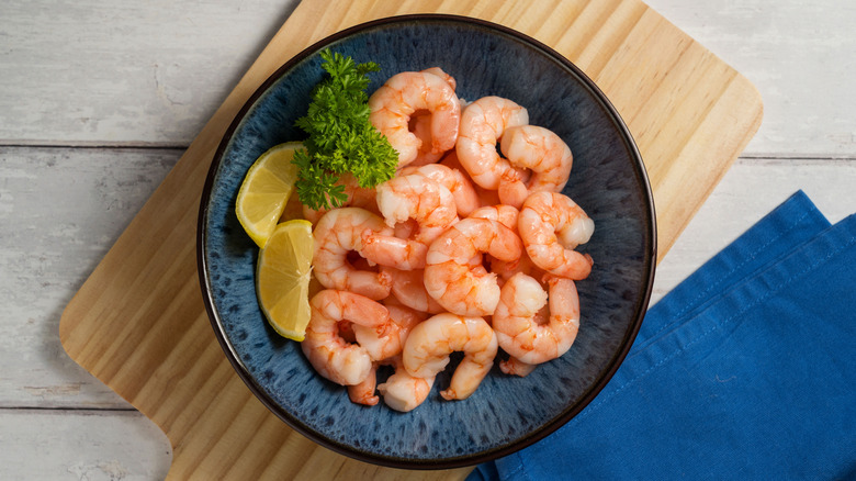 shrimp in blue bowl with lemon wedges