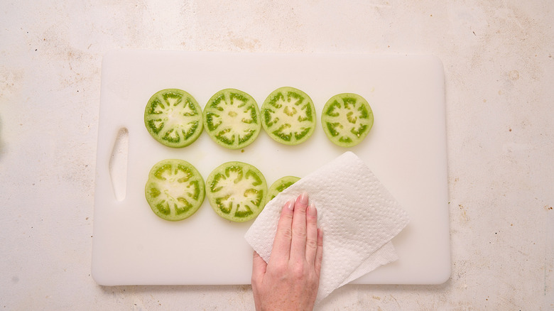 slicing and drying tomatoes on cutting board