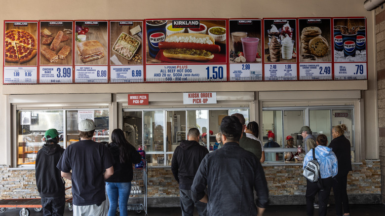 People wait in line at the food court at a Costco warehouse