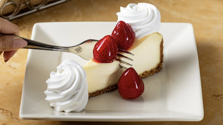 Cheesecake slice with strawberries and whipped cream
