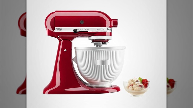 Red KitchenAid mixer with ice cream making bowl attached next to bowl of ice cream