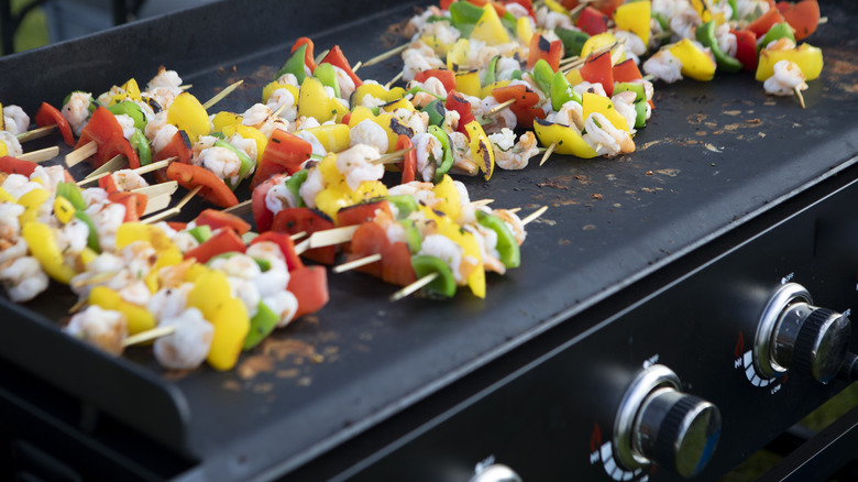 skewered ingredients cooking on griddle