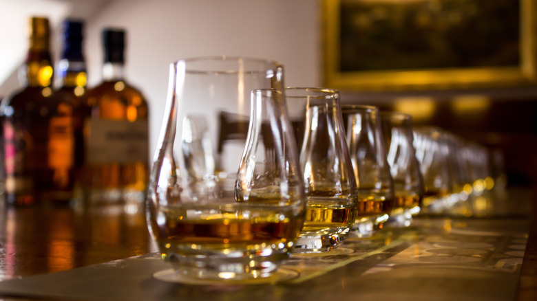 A line of tasting glasses filled with different types of whiskies