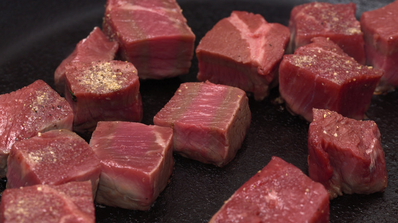 Searing cubes meat in a plan