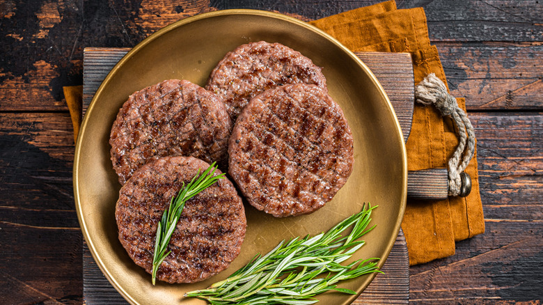 Burger patties and rosemary on a plate