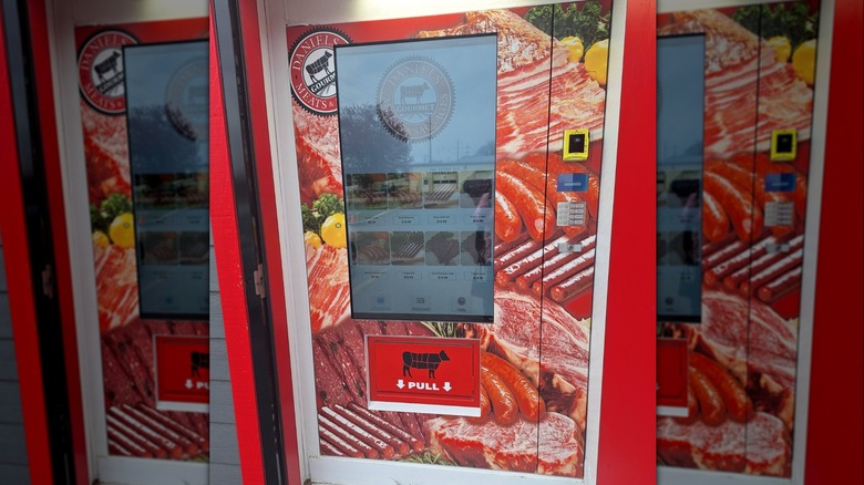 a steak vending machine featuring a touch screen and an image of various meats on the exterior