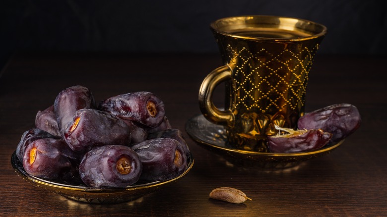 Dates beside a coffee cup