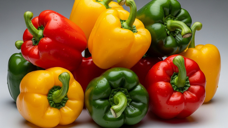 a pile of red, green and yellow bell peppers
