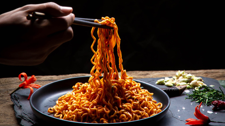chopsticks lifting spicy noodles