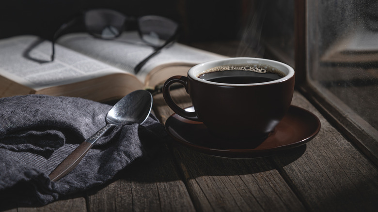 Mug of coffee beside a window at night