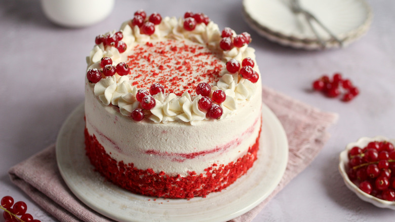 a beautifully frosted red velvet cake on a plate