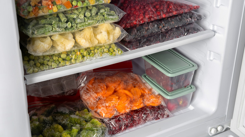 Inside view of a freezer with clear bags of frozen vegetables neatly organized.