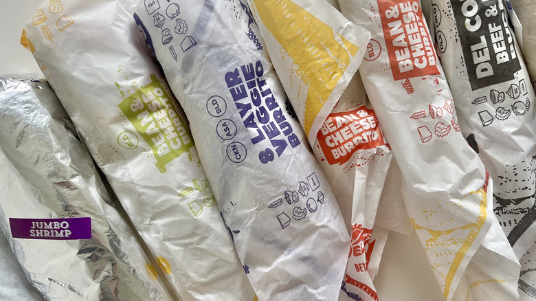 Top view of burritos in wrappers on a table