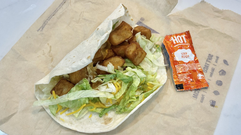 Taco Bell Spicy Potato Soft Taco with sauce on wrapper.