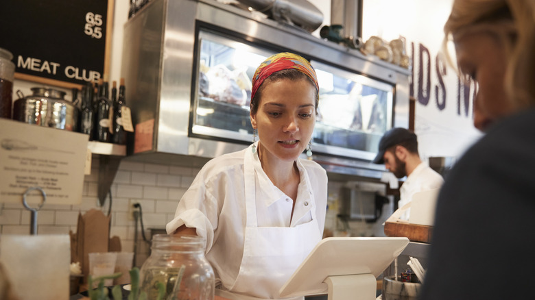 woman serving a customer in deli setting