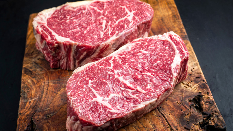 two thick steaks served on cutting board