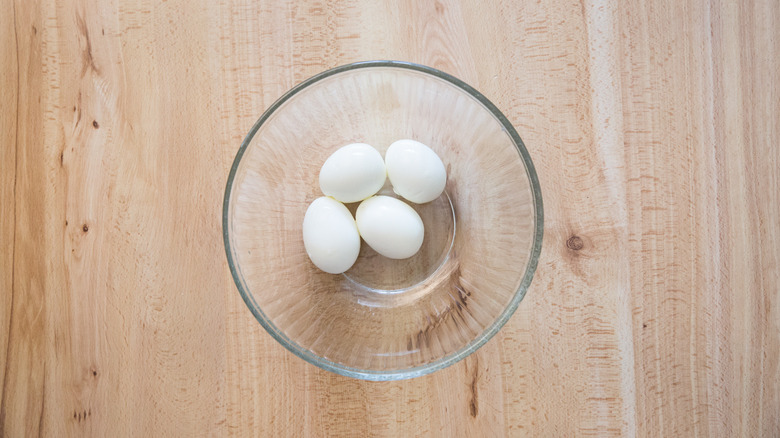 peeled eggs in glass bowl
