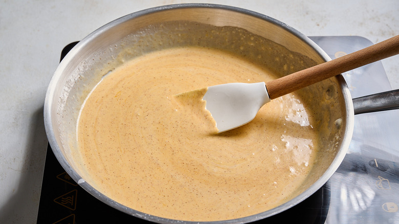 stirring the cheese and seasonings into the sauce